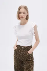 Remera blanca de algodón con cuello redondo, corte al cuerpo y mangas cortas con volados.