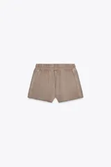 Shorts de tiro alto confeccionados en tejido con efecto lavado, cintura elástica ajustable con cordones, bolsillos laterales de vivo y tejido combinado en rib a tono.
