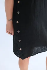 Vestido negro de lino italiano con corte suelto, escote redondeado, mangas cortas y botones decorativos en los costados.