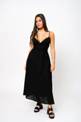 Vestido largo negro con escote en V, tirantes finos y espalda baja. Tiene frunces en la cintura que realzan la silueta.