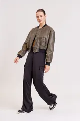 Pantalón de vestir color verde oliva, de corte ancho y tiro alto, con bolsillos laterales tipo cargo y detalle de pinzas en la cintura.