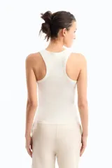 Musculosa blanca de algodón pima con lycra, calce fitted, escote en "U" y espalda deportiva. Detalle de cartera de botones a tono personalizados y bordado marcario a tono en el frente.