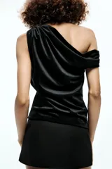 Falda pantalón color crema de tiro bajo con cintura asimétrica, bolsillos delanteros de vivo y cierre lateral con cremallera oculta.