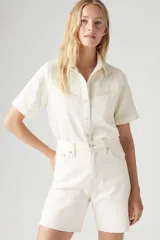 Camisa color crema de manga corta con cuello clásico, cierre frontal con botones y dos bolsillos con solapa en el pecho.