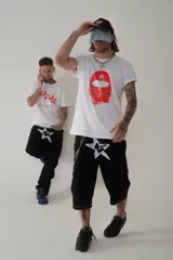 Pantalón negro de corte acampanado con detalles de costuras rojas y bolsillos con diseño.