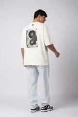 Remera color crema de corte oversize con la palabra "Rewind" bordada en el frente.