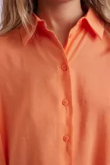 Camisa naranja fluida de manga corta con cuello clásico y cierre con botones.