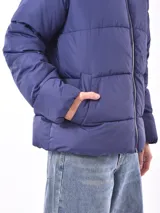 Campera puffer color gris topo, con cuello alto y cierre frontal.