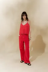 Musculosa de lino color crudo con rayas verticales finas en negro, escote en V y breteles finos regulables con detalle de borlas.