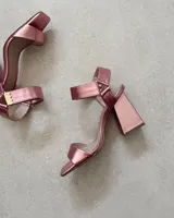 Sandalias plateadas con tira delantera, tobillera con hebilla y taco geométrico.