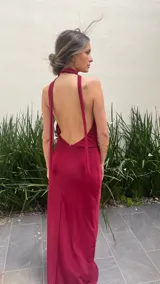 Vestido largo color borgoña, con escote drapeado y cuello halter. Tiene forro corto con transparencia.