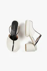 Mule color caramelo con plataforma y taco cilíndrico, tira superior negra y puntera cuadrada.