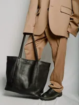 Bolso tote de cuero color marrón con cierre superior y doble asa de hombro. Incluye bolsillo interior y llavero.