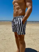 Short de baño negro con rayas verticales blancas, cintura elástica con cordón ajustable y logo de la marca en la pierna.