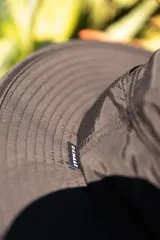 Sombrero negro tipo pescador con ala ancha, cordón ajustable naranja y parche frontal con logo de la marca Denali.