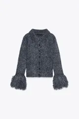Chaqueta de punto azul con cuello solapa, manga larga y flecos en las mangas. Cierre frontal con botones.