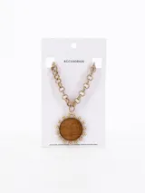 Collar dorado con cadena de eslabones y dije circular de madera con borde de bolitas doradas.