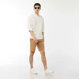 Camisa blanca de manga larga con cuello mao y textura gofrada.