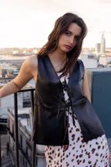 Chaleco azul de cuero ovino con escote en V y lazos de ajuste frontales.