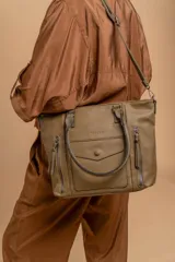 Cartera bandolera de símil cuero color marrón claro, con doble asa rígida y correa regulable. Presenta dos bolsillos frontales con cierre vertical y un bolsillo frontal con solapa y botón. Cuenta con dos divisiones internas.