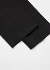 Pantalón negro de diseño crop, corte skinny y tiro medio. Cuenta con trabillas, dos bolsillos laterales, dos bolsillos de ribete en la parte posterior, cierre de cremallera y botón, y forro interior.