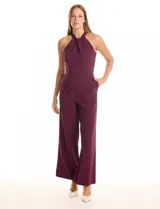 Enterito largo de crepe color rojo, con escote halter anudado y pierna ancha. Presenta bolsillos delanteros y abertura en la espalda con cierre invisible y botón.