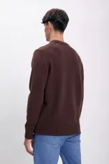 Sweater marrón de punto con cuello redondo y mangas largas.