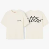 Camiseta de corte oversize color crema, con estampado gráfico en la parte trasera y logo en el frontal.