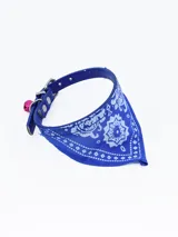 Collar negro de cuero sintético con hebilla plateada, bandana estampada en blanco y negro y cascabel rojo.