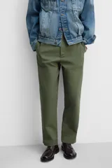 Pantalón chino color verde militar, de corte recto, con bolsillos laterales y traseros de vivo. Cierre frontal con cremallera y botón.