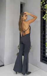 Catsuit negro con espalda descubierta y pantalones acampanados.