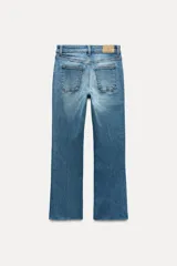 Jeans de tiro alto con bolsillos de plastrón en delantero y espalda, corte mini flare y largo cropped. Cierre frontal con cremallera y botón metálico.