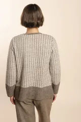 Cardigan tejido con efecto fantasia color crema. Una prenda de silueta amplia y cómoda. Tejido en 100% lana fina sin teñir.