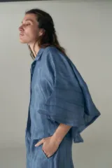 Conjunto de camisa y pantalón celeste con textura arrugada. La camisa es crop con cuello clásico y mangas cortas. El pantalón es de corte ancho con cintura elastizada y cordón ajustable.