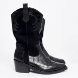 Bota texana de caña alta color marrón claro, confeccionada en cuero vacuno con detalles de bordado y apliques en relieve. Tiene cierre lateral, taco de madera con folia de cuero y suela de goma. La horma es de punta fina, ancha y cómoda.