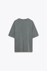 Camiseta gris de algodón con efecto lavado, cuello redondo, manga corta y parches estampados en el frente.