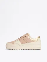 Zapatillas Tommy Hilfiger color crema y rosa pálido, con detalles dorados en el talón y logo de la marca en el lateral.
