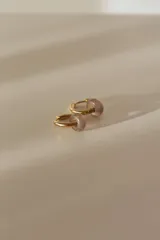 Par de aros tipo argolla dorados con dije de piedra natural con patrón de manchas negras sobre fondo blanco.