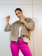 Chaqueta corta color camel con cuello alto, cierre frontal con botones y mangas 3/4 acampanadas.