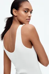 Musculosa de punto fino color blanco, entallada con escote en U adelante y atrás.