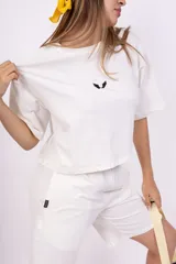 Remera blanca de corte holgado con logo pequeño bordado en negro en el pecho.