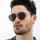 Lentes de sol INVU modelo IB12515A, con montura metálica color gris plomo y lentes polarizadas grises de forma redonda.