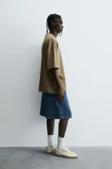 Camiseta color beige de corte holgado, cuello redondo y manga corta.