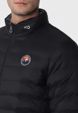 Campera reversible acolchada en color marrón, con emblema distintivo en la manga y capucha.