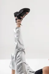 Sandalia de cuero negra con tiras entrecruzadas y cordones para atar al tobillo. Plataforma con suela track.