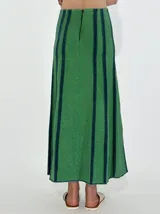 Pollera larga de jean azul con corte acampanado y costuras verticales en color ladrillo.