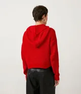 Buzo de tejido chenille texturizado en color rojo, con capucha ajustable mediante cordones y puños y ruedo acanalados.