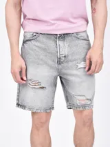 Bermuda de jean azul con roturas y desgaste.