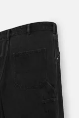 Pantalón de jean negro, corte relaxed fit, con bolsillos frontales y traseros tipo parche, tira multifunción y bolsillo tipo parche en las piernas. Tiene efecto lavado y cierre frontal con cremallera y botón.