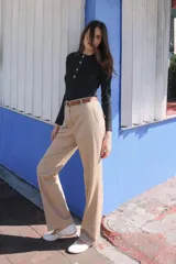 Pantalón negro de tiro alto con pernera recta, bolsillos frontales y falsos bolsillos con solapa en la espalda. Incluye cinturón marrón de cuero sintético.